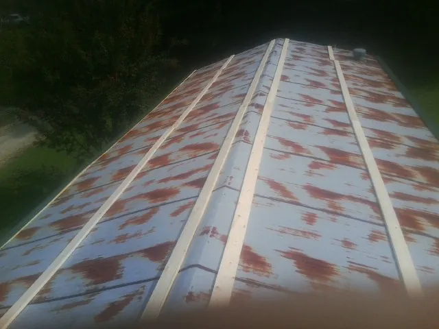 Rusted metal roof panels with new wood purlins before replacement — Storm Damage Roof Repair in Vienna by Roofing Brothers